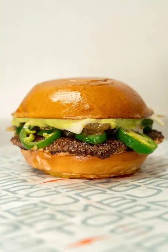 Jalapeño Lightning Burger at StormBurger — Fresh buns, homemade avocado crema, homemade storm sauce, 4oz all-natural patty, swiss cheese, grilled onions, jalapenos